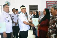 Bupati Lamtim, H. M. Dawam Rahardjo, menyerahkan langsung sertifikat PTSL kepada masyarakat desa sumur bandung. (*Ist) 