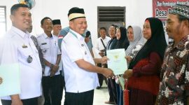 Bupati Lamtim, H. M. Dawam Rahardjo, menyerahkan langsung sertifikat PTSL kepada masyarakat desa sumur bandung. (*Ist) 