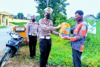 Kasat Lantas Polres Lampung Timur, IPTU Bima Alief Caesar Gumilang menyerahkan paket sembako kepada masyarakat terdampak kenaikan harga BBM. Selasa (06/09/2022). (*Fer/Kroscek.net) 