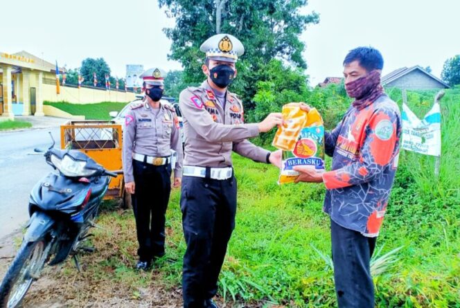 Kasat Lantas Polres Lampung Timur, IPTU Bima Alief Caesar Gumilang menyerahkan paket sembako kepada masyarakat terdampak kenaikan harga BBM. Selasa (06/09/2022). (*Fer/Kroscek.net) 