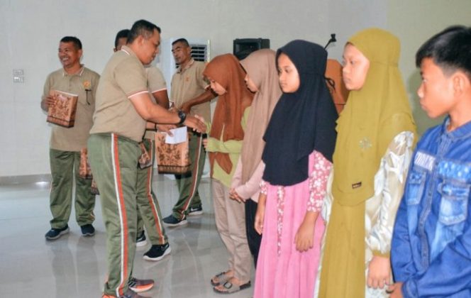 Komandan Korem 022/Pantai Timur, Kolonel Inf Luqman Arief, S.I.P., menyerahkan bingkisab kepada anak yatim piatu di Aula Pantai Timur Makorem 022/PT, Jum'at (07/10/2022). (*Ist) 