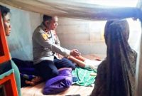 Kapolsek Routa, Ipda Muhdin Tidore, bersama personelnya mengunjungi Merida (2) di tempat tidurnya, anak dari pasangan Cecen dan Dira. Minggu (16/10/2022). (*Ist) 
