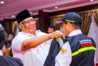 H. Ali Mazi memasangkan rompi Petugas Haji Daerah, Petugas Penyelenggaraan Ibadah Haji dan Tim Kesehatan Haji Indonesia Provinsi Sulawesi Tenggara Tahun 1444 H/2023 M. Aula Rujab Gubernur. Rabu, (17/05/2023).(*Ist)