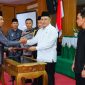 Penandatanganan Raperda menjadi Perda oleh Bupati H. Ruksamin, diserahkan langsung oleh wakil ketua DPRD Konut, I Made Tarubuana. 