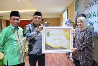 Karo Kesra Pemprov Sultra, Iwan Susanto menyerahkan Piagam penghargaan penyelengaraan ibadah haji berlangsung di Hotel Plaza Kubha Kendari. Senin, (05/08/2024).