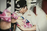 Dr. Ir. H. Ruksamin, S.T., M.Si., IPU., ASEAN Eng., terlihat dengan penuh kasih sayang menggendong salah satu bayi warga.